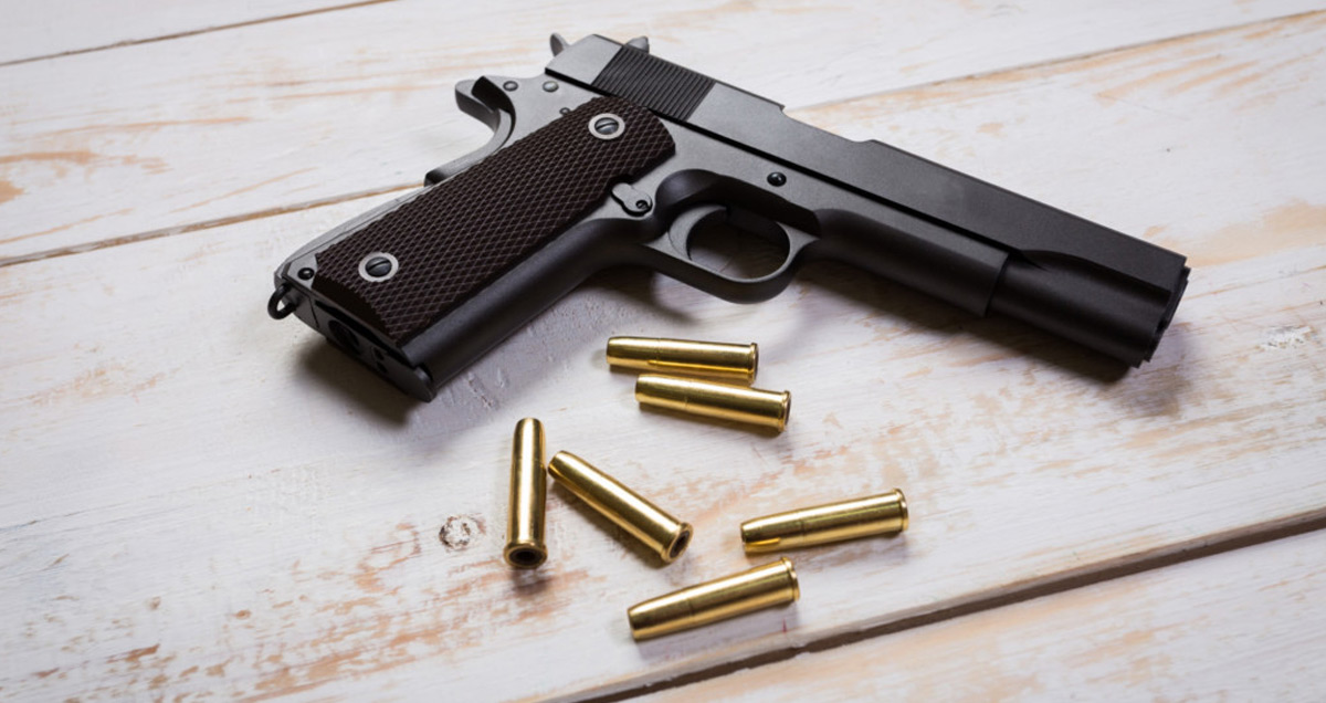 hand-gun-with-rounds-on-wooden Cleaning 101: Why Cleaning Your Gun is Important